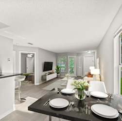 A modern dining room with a black table set for two. at Aqua Bay Apartments in Naples, FL 34116