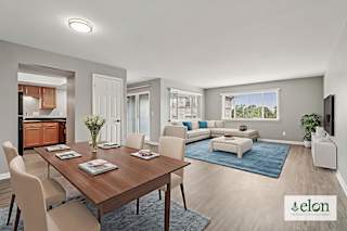 A modern dining room with a wooden table and chairs.