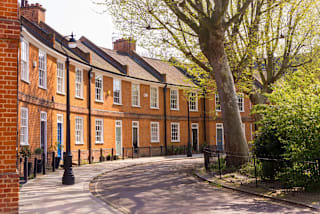 A tree in front of a red brick building.