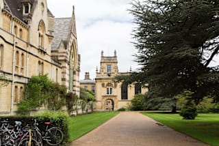 A pathway leads to a large, stately building with a tower.