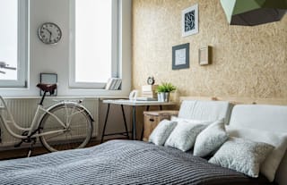 A bedroom with a bed, desk, and a bicycle.