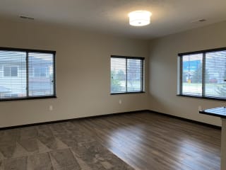 Living and dining area with three windows at the villas at mahoney park