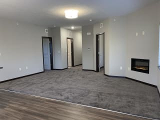 Carpeted living area with built in electric fire place at the villas at mahoney park