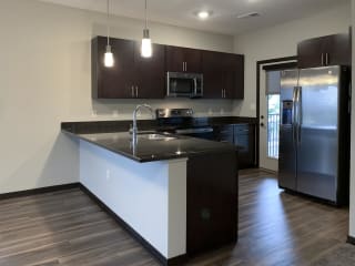 kitchen with dark brown cabinets and L shaped counter at the villas at mahoney park