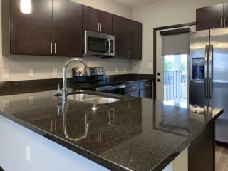 Kitchen with dark brown cabinets and matching stainless steel appliances at the villas of mahoney park