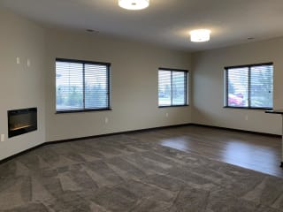 Living and dining area with three windows at the villas at mahoney park