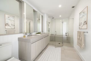a bathroom with white walls and floors and a glass shower stall