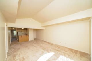 the living room and kitchen of an empty house with no furniture