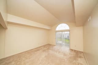 an empty living room with a door to a patio