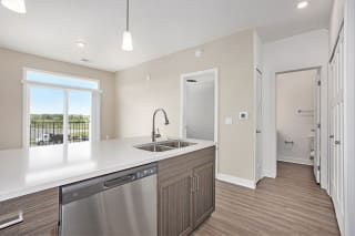 a kitchen with a sink and a door to a hallway