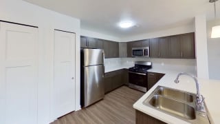 a kitchen with a stainless steel refrigerator and a sink a kitchen with a stainless steel refrigerator and a sink at Meadowbrooke Apartment Homes, Grand Rapids