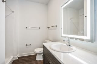 a bathroom with a sink and a toilet and a mirror a bathroom with a sink and a toilet and a mirror at Meadowbrooke Apartment Homes, Grand Rapids, MI, 49512