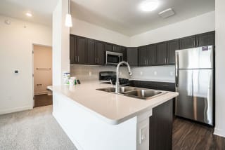 a kitchen with a sink and a stainless steel refrigerator a kitchen with a sink and a stainless steel refrigerator at Meadowbrooke Apartment Homes, Grand Rapids, Michigan