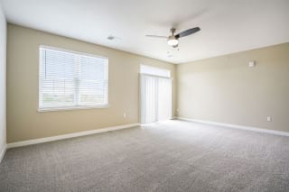 an empty living room with a ceiling fan and a window an empty living room with a ceiling fan and a window at Meadowbrooke Apartment Homes, Grand Rapids, Michigan