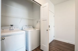 a white laundry room with two washes and a dryer a white laundry room with two washes and a dryer at Meadowbrooke Apartment Homes, Michigan
