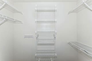 a white room with a row of shelves on the wall
