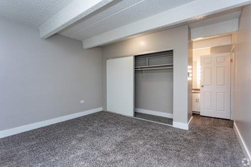 A room with a grey carpet and white walls.