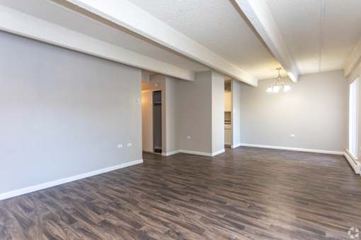 A room with wooden flooring and white walls.