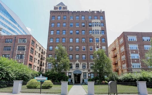 a tall brick building with a sidewalk in front of it