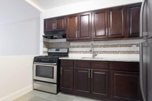 a kitchen with dark wood cabinets and stainless steel appliances