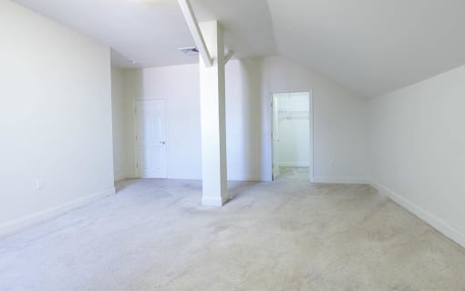 an empty living room with white walls and concrete floors
