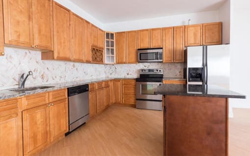 a large kitchen with wooden cabinets and stainless steel appliances