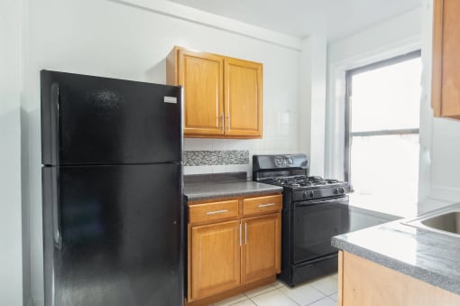 a kitchen with black appliances and wooden cabinets