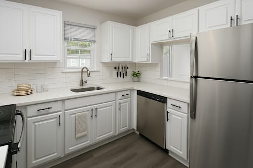 A kitchen with white cabinets and a stainless steel refrigerator.