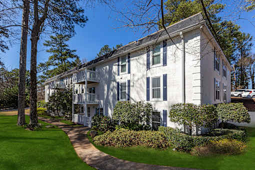 A white building with a green lawn in front.