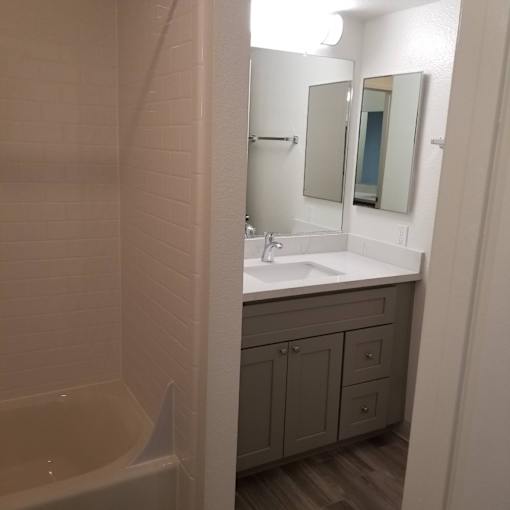 A white sink is in a bathroom with a white tub.