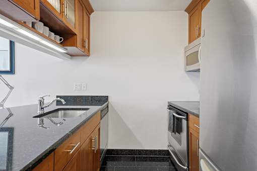 A kitchen with a sink, stove, and microwave.