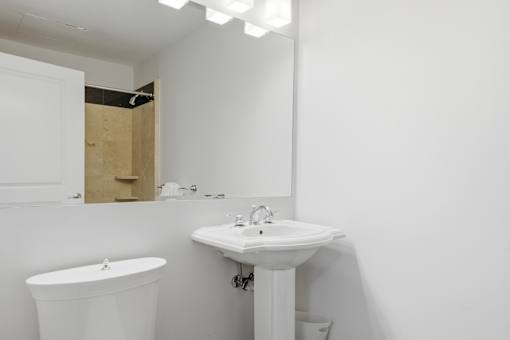 A white bathroom with a sink, toilet and bathtub.