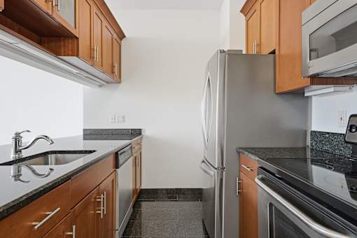 A kitchen with a refrigerator, sink, and microwave.