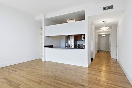A white kitchen with wooden floors and a white ceiling.