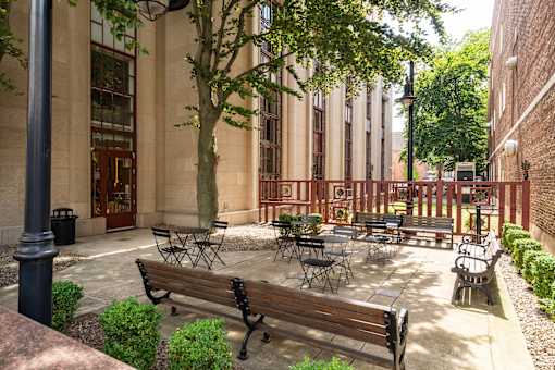 A courtyard with tables and chairs surrounded by buildings.
