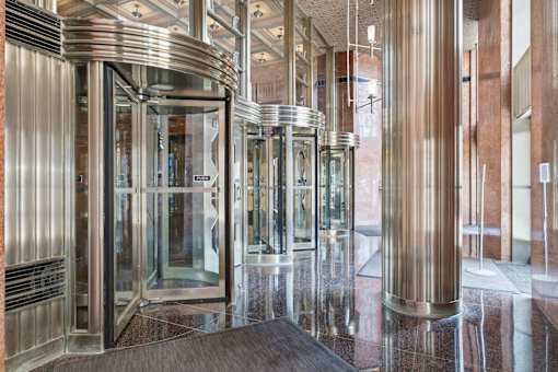 A set of shiny metal turnstiles in a building.