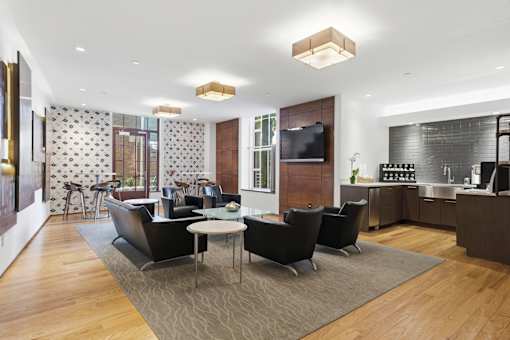 A modern living room with a television, a kitchen area, and a dining table.
