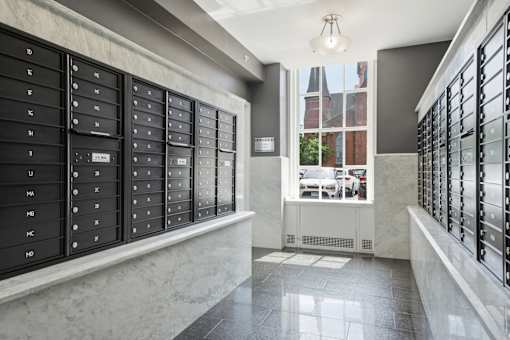 A row of black mailboxes on a marble ledge.