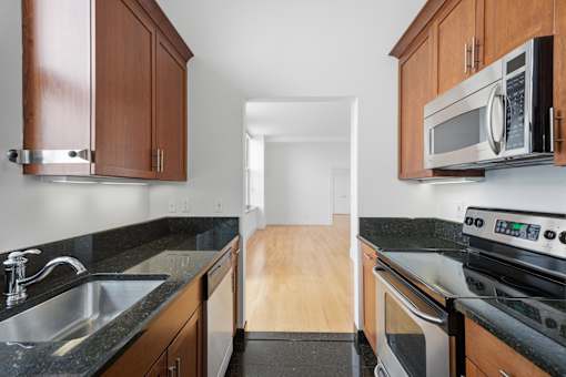 A kitchen with a sink, stove, and microwave.