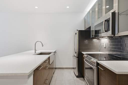 A modern kitchen with stainless steel appliances and wooden cabinets.
