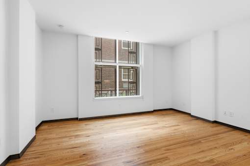 Empty room with wooden floor and a window.