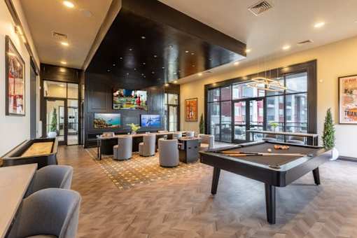 A room with a pool table and a bar.