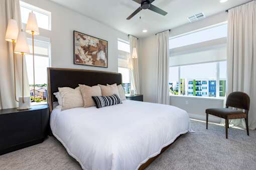 A bedroom with a large bed and a ceiling fan.