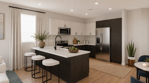 A modern open kitchen with bar stools and a refrigerator.