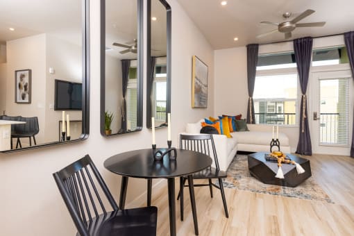 Solasta apartment dining area open to living room with ceiling fan and balcony