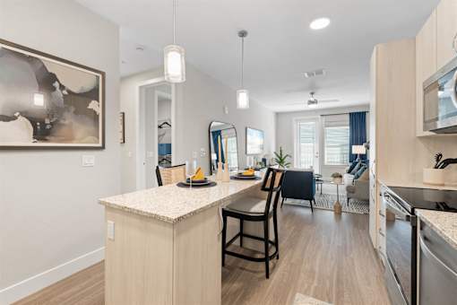 an open kitchen and dining area with a large island and a living room at Mira at Palmer Ranch, Sarasota, FL