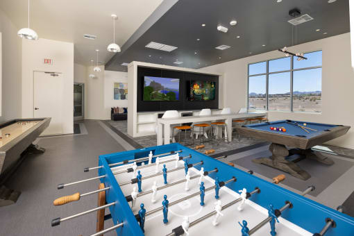 a game room with a foosball table and a flat screen tv