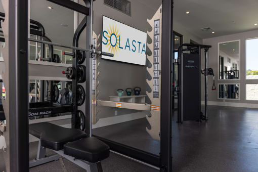 a gym with squat racks and a sign on the wall