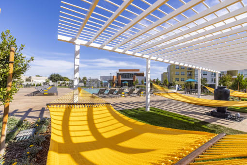 a group of yellow hammocks under a white shad at Solasta, Sacramento, CA, 95831