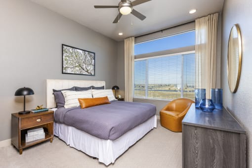 apartment bedroom has a large window and lighted ceiling fan at Zeta Luxury Apartments in Sacramento, CA